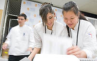 FIU-FriFoodPrep-6913 -  FIU School of Hospitality students Nilly Zorrilla, center, and Meiling Chan, right check their food list while preparing for the South Beach Wine and Food Festival at the Miami Beach Convention Center kitchen.