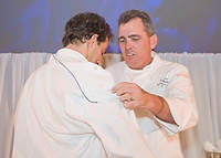 FIU-Tribute-0144 - FIU School of Hospitality Professor Chef Michael Moran, right, presents a new chefs jacket to with FIU School of Hospitality student and winner of the Barilla Best New Student Chef Award for 2008 Michael Cremeno. (Photo by Michell Zachs/FIU School of Hospitality)