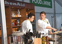 FIU-Grd-Taste-0216 - FIU School of Hospitality student, Alex Kuk, right, is among many FIU students responsible for ensuring the stages are completely set up and ready for celebrity chefs to perform their cooking shows in the Grand Tasting Village of the 2008 South Beach Wine and Food Festival in Miami Beach.