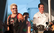 FIU-WF09-033845 - Food Network's Guy Fieri, left, is among hundreds of chefs gathered together for Florida International University School of Hospitality's annual fundraiser South Beach Wine and Food Festival to raise money for student scholarships Saturday, February, 21, 2009 at SBWF in Miami Beach, Fl. At right is FIU student chef  Johnny Suggs assisting celebrity chef Fieri on stage at the Grand Tasting Village.