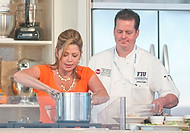 FIU-682-WF105607 - Celebrity Chef Daisy Martinez is helped on stage by FIU School of Hopitality student Johnny Suggs at the Grand Tasting village of the 2010 South Beach Wine and Food Festival.