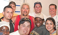 FIU-700-WF105761 - Celebrity Chef Guy Fieri, top third from right, congratulates FIU School of Hopitality students and staff on a job well done in the kitchen at the Grand Tasting village of the 2010 South Beach Wine and Food Festival.